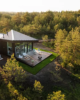 Modern outdoor living space with the contemporary Mix 850 fire pit creating warmth and atmosphere on a patio beside a glass-walled home